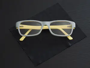 Yellow and gray glasses on a black cloth with a striped pattern