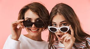 Two women wearing sunglasses and smiling for a photo