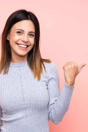woman in grey sweater smiling and pointing
