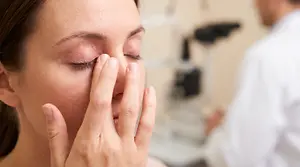 Woman with chalazion on her eye, in a clinic with a doctor examining her eye