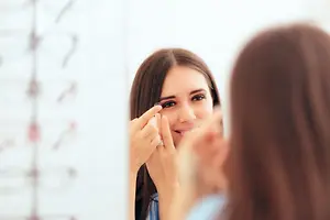 woman putting contact lens