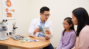 An eye doctor discusses myopia management with a child and her mother.