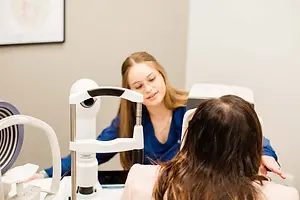 A woman is having her eyes checked by an optometrist