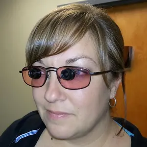 Woman wearing tinted glasses with magnifying lenses