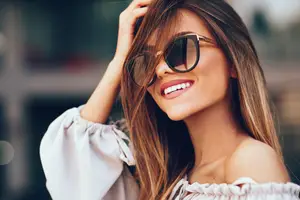 Smiling woman in sunglasses looking to the camera