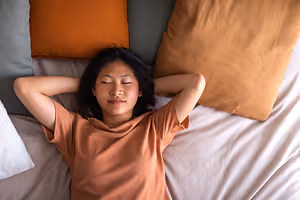 Woman sleeping peacefully on a bed with her eyes closed