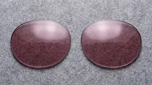Two round purple colored lenses on a gray surface.