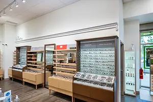 A collection of glasses on display in a retail shop with white walls and wooden floors