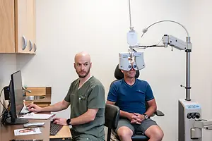 A doctor with a patient during an eye exam in an exam room