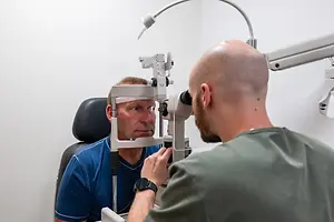 Man getting his eyes checked by an optometrist at the optical clinic