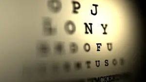 An image of a blurry eye chart with letters and numbers for vision testing