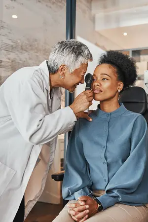 Doctor examining the eye of a patient with an ophthalmoscope