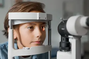 A young boy is having an eye exam at the optometrist's office.