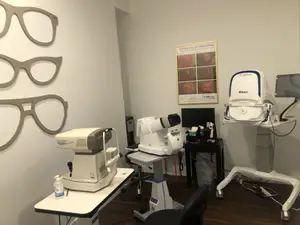 An eye doctor's office with various machines and a poster on the wall