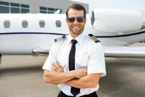 Pilot in uniform standing next to a plane