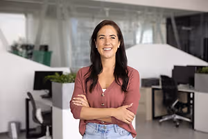 Smiling woman in a red sweater in an office with white furniture
