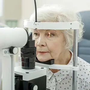 Old woman sitting in a chair undergoing an eye exam