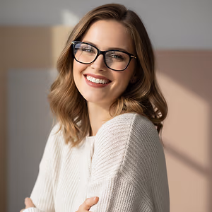 Woman wearing glasses and a white sweater smiling