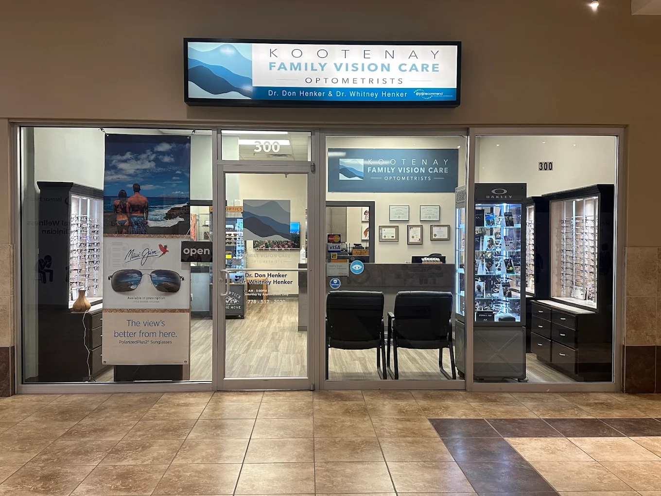 A storefront for Kootenay Family Vision Care, featuring a large sign above the entrance, display cases for eyewear, and an interior view with chairs and shelves