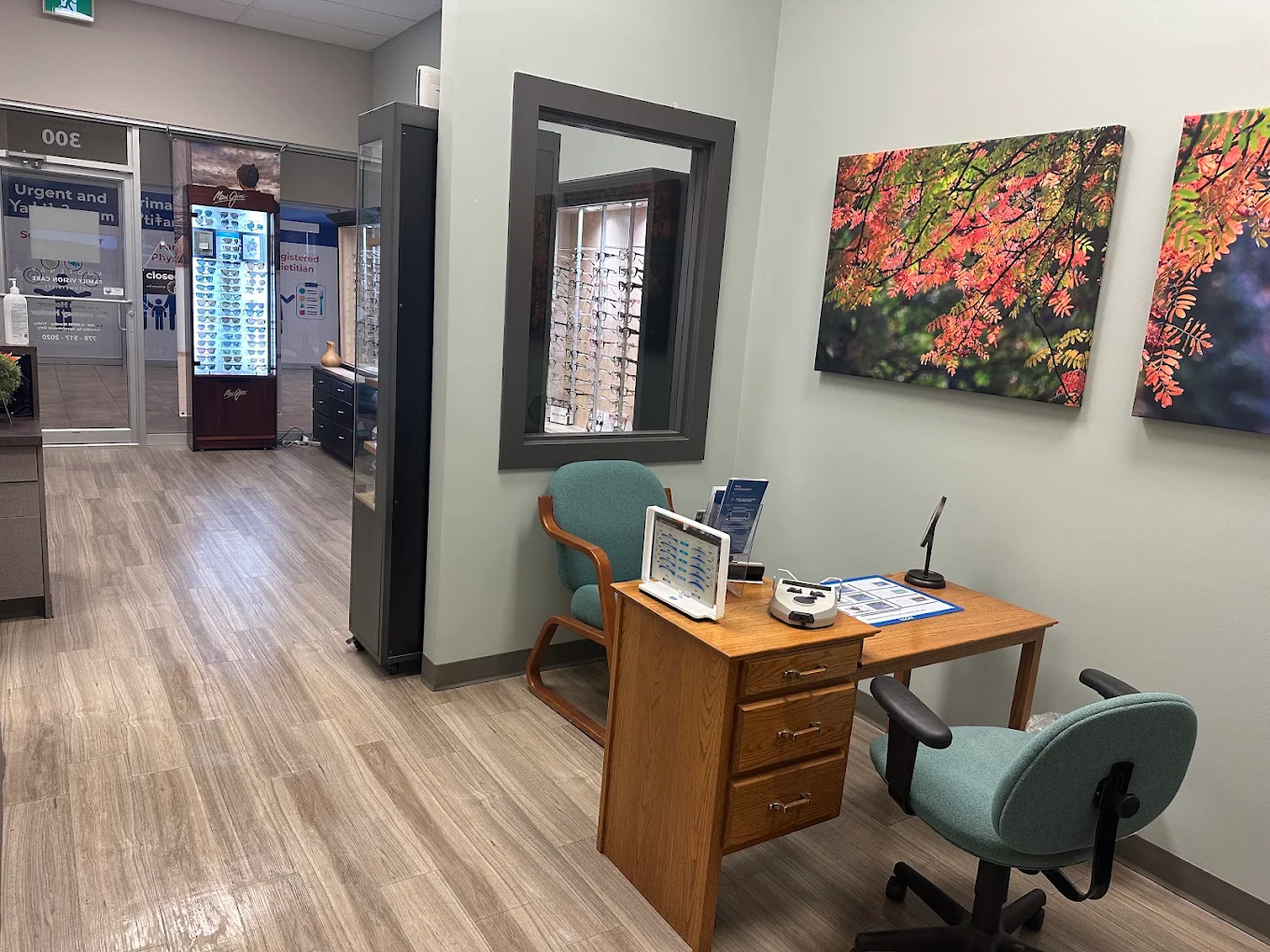 Interior of an Cranbrook optometrist's office with a desk, chairs, and artwork on the walls.