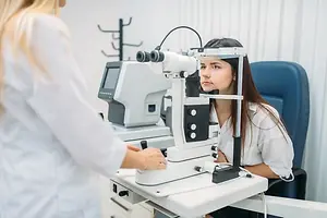 A woman is getting her eyes checked by an eye doctor using an eye examination machine