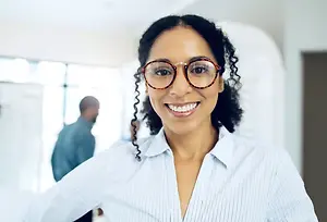 Happy businesswoman with glasses smiling in an office setting