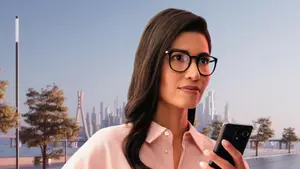 A woman with glasses stands on a city street, holding a cell phone and looking at the camera.