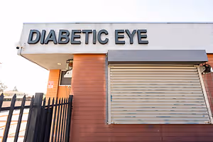 A sign reading Diabetic Eye above a window with a metal gate