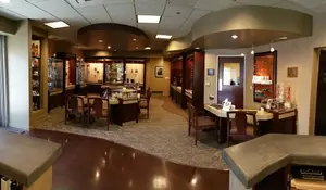 A room with a table and chairs and a counter with a monitor and other objects in a store.