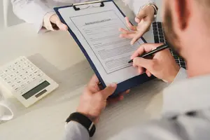 A man filling out an insurance claim form