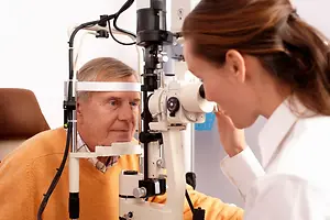 An elderly man having an eye test with an optician