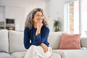 woman sitting on a sofa in a living room smiling