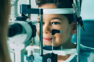 A boy getting his eyes examined by a doctor