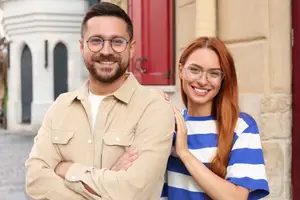 A man and a woman standing next to each other and smiling for a photo