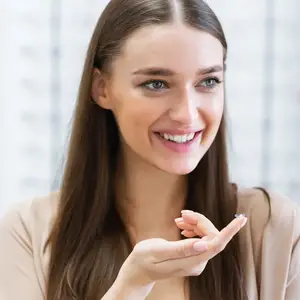 A lady holding a contact lens