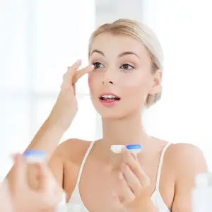 Lady in front of a mirror wearing contact lens