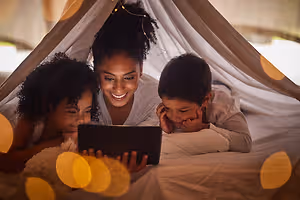 A family using a tablet in a tent