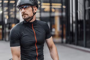 A man wearing a helmet and sunglasses on a street