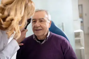 Doctor examining a patient's ear with an otoscope
