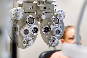 An optometrist's ophthalmoscope with several dials and lenses used for examining patients' eyes in a clinical setting.