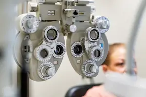 An optometrist's ophthalmoscope with several dials and lenses used for examining patients' eyes in a clinical setting.