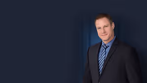 A man in a suit and tie smiling for a picture
