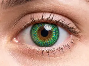 A close up of a person's eye with green and blue iris patterns