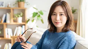 Woman holding glasses in living room