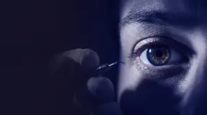 Close-up of a person's eye with a needle, likely a medical procedure