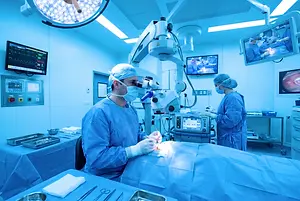 Two doctors performing surgery in an operating room with advanced medical equipment and monitors