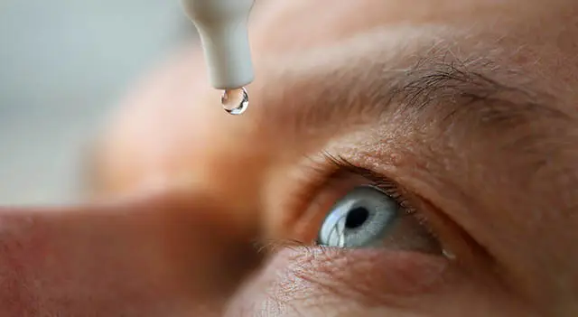 Close-up of a man's eye with a drop of eye medication about to be administered